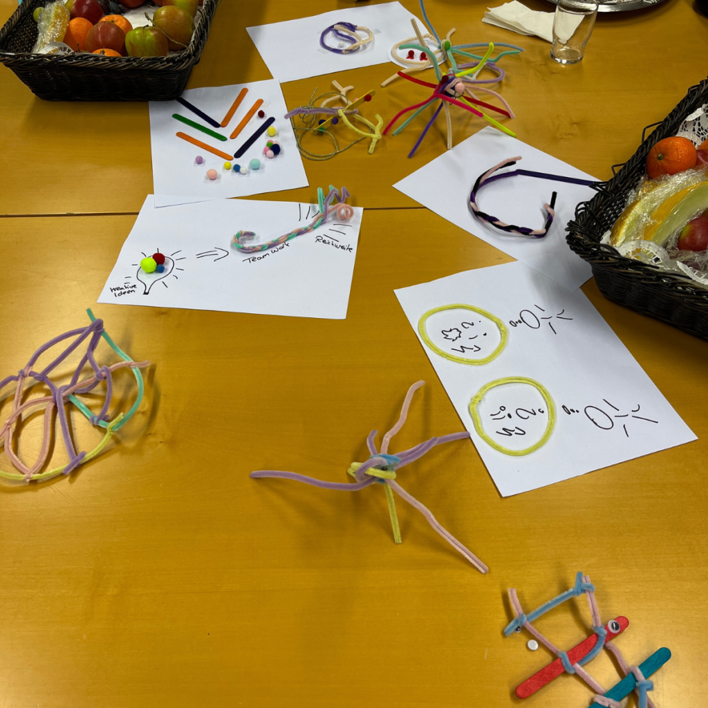 Pfeiffenputzer zu Figuren zusammen gebastelt: Superkraft-Check-in beim kreativen Workshop-Check-in.